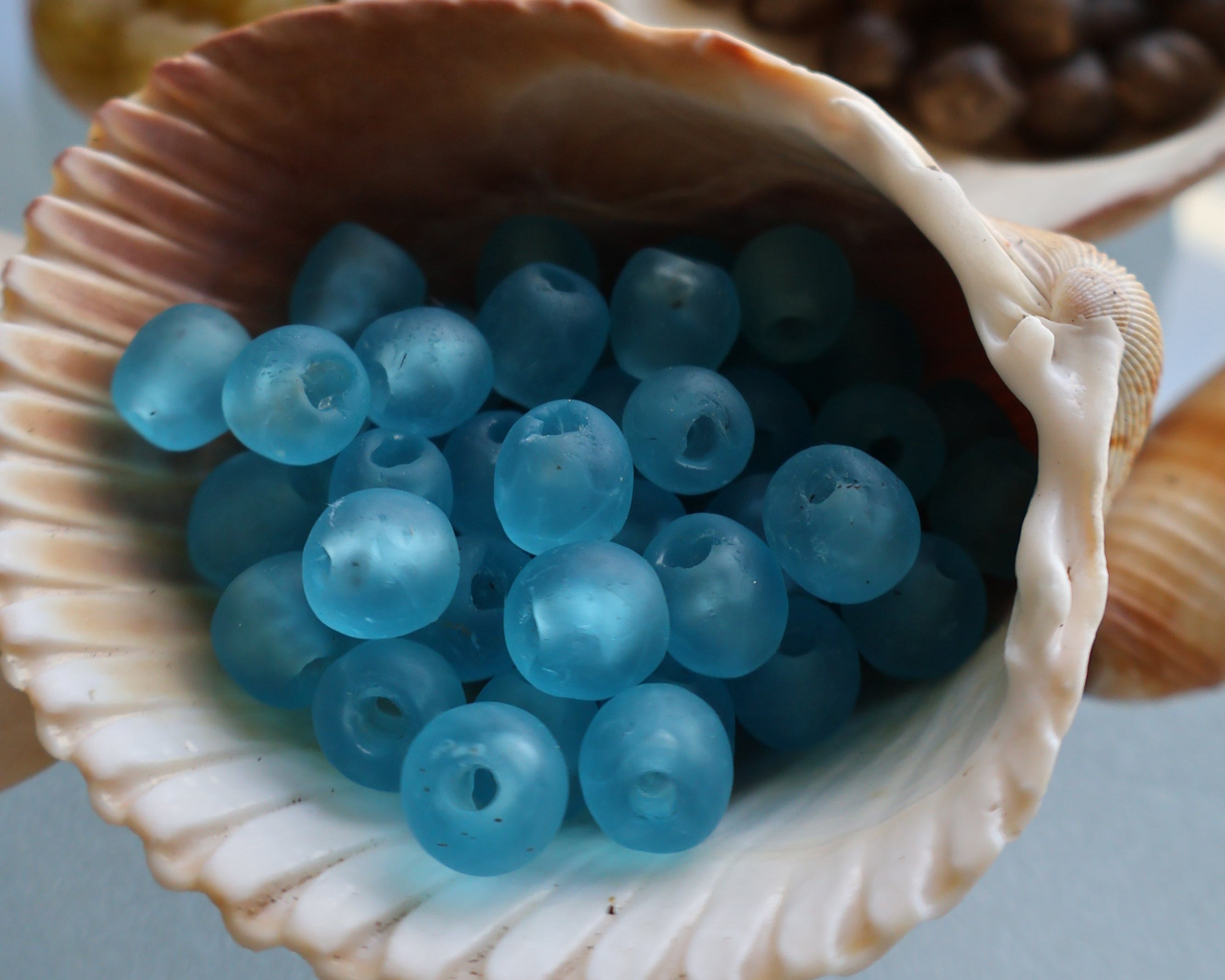 Blue beads in a shell with other colored beads in the background