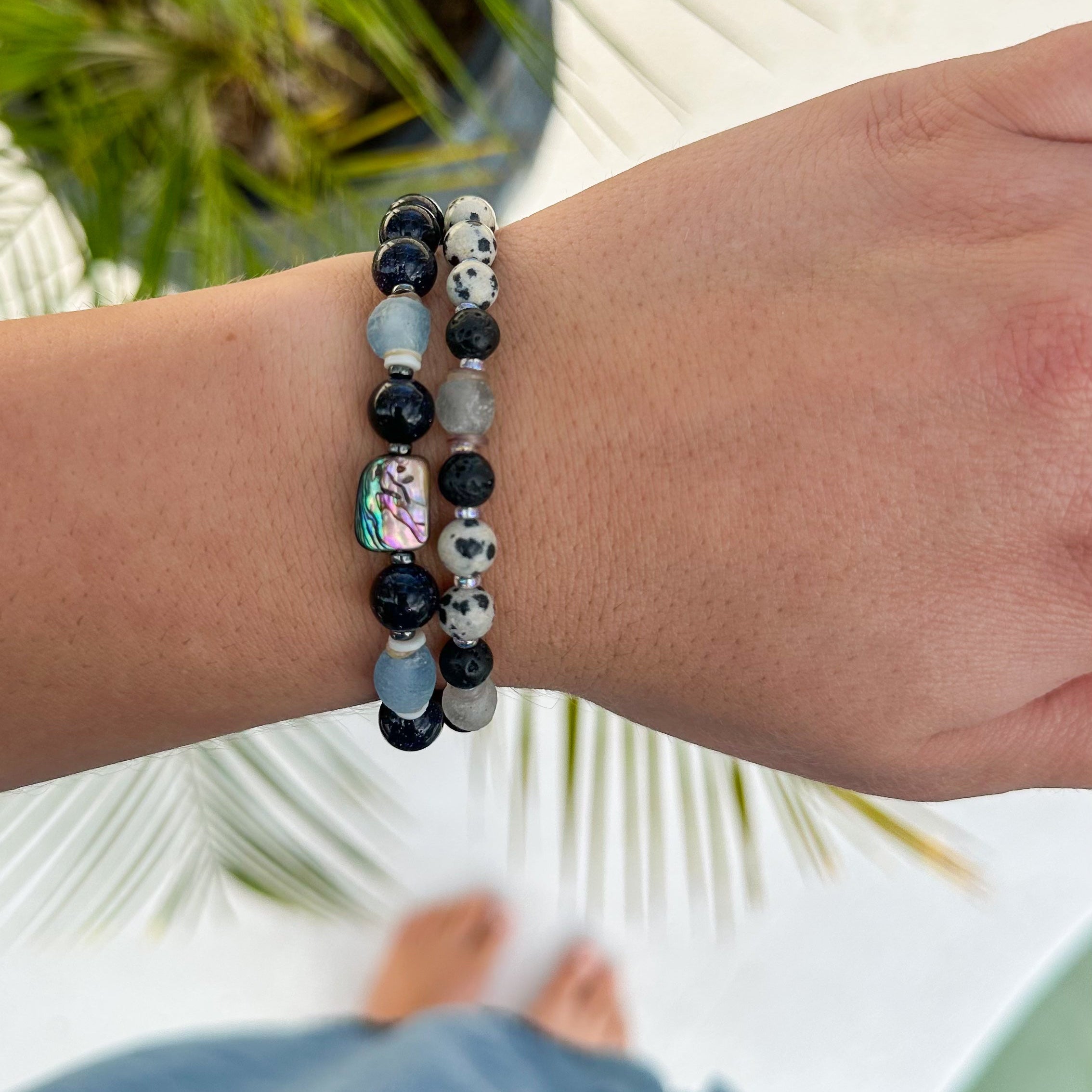 Close-up of a wrist wearing a beaded bracelet with a blurred outdoor background